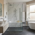 Modern bathroom with carara white pvc wall panels, a freestanding bathtub, and a glass shower enclosure.