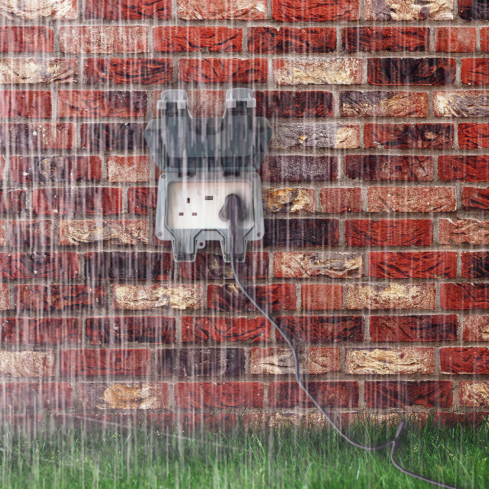 ENER-J IP65 waterproof outdoor socket mounted on brick wall during heavy rain