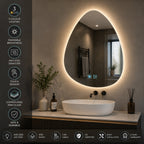 Teardrop-shaped LED backlit bathroom mirror with a white vessel sink on a marble countertop, shown in a modern bathroom setting with feature callouts on the left.