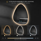 A smart LED lighted mirror with an organic teardrop shape, shown in a dark bathroom setting with a bathtub visible in the reflection. The image features three color options for the LED light border: Warm White, Natural White, and Cool White, displayed in a row at the bottom.